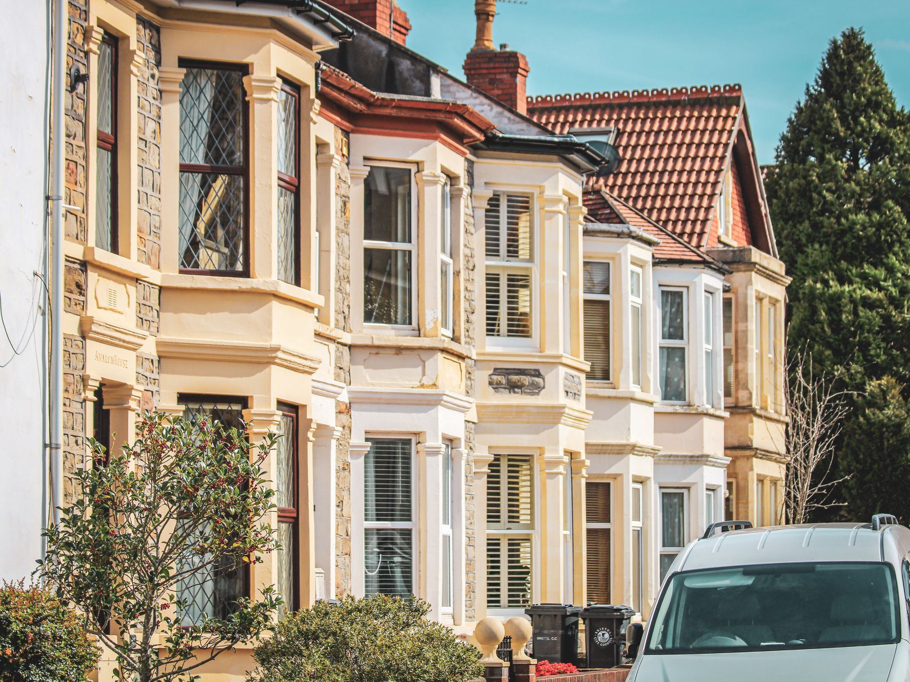 Elegant row houses with classic architecture on a sunny street in Bristol, UK.